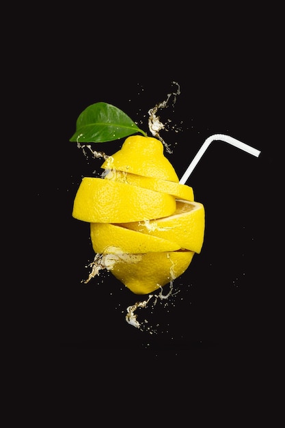 Summer refreshing drink. levitation of lemon slices with a\
straw on brown background. levitation of freshly cut lemon,\
vertical, closeup.