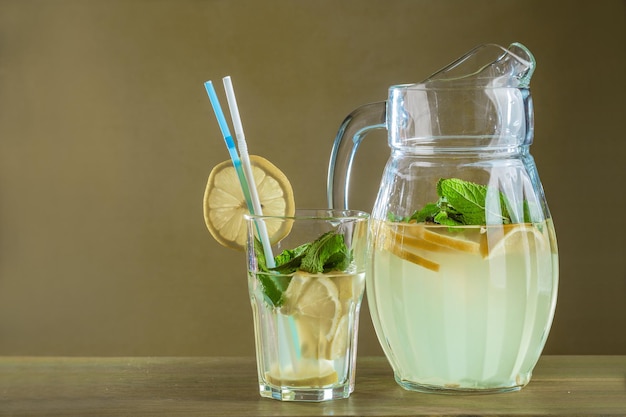 Summer refreshing drink with lemon and ice in a decanter