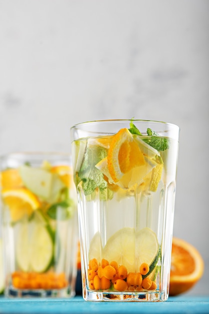 Summer refreshing lemonade with orange, lemon, mint in glasses