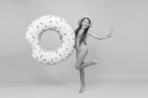 Photo summer resort recreation concept hotel with swimming pool little girl and swimming donut ring kid in swimsuit relaxing and having fun summer vacation cheerful kid relaxing relaxing at pool