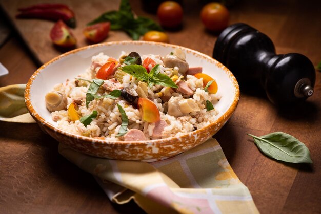 Summer rice salad with vegetables and fresh herbs close up