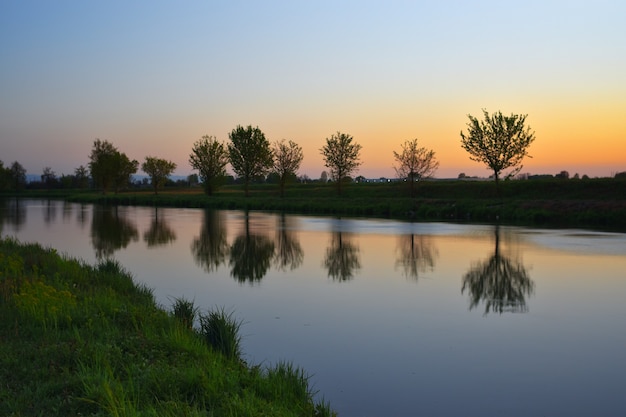 Estate sul fiume con un incredibile tramonto colorato