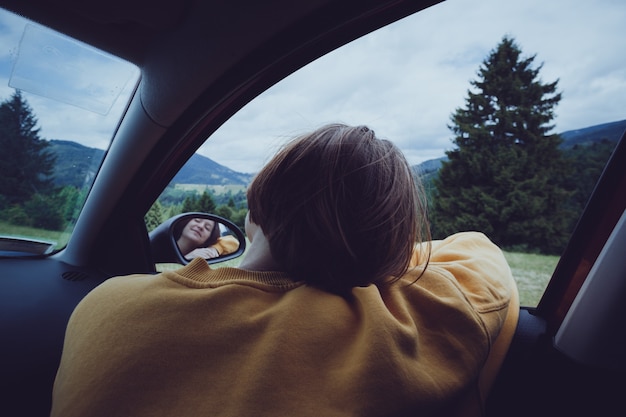 写真 夏のロードトリップ。山を渡って車で旅行している幸せな美しい少女。ルーマニア