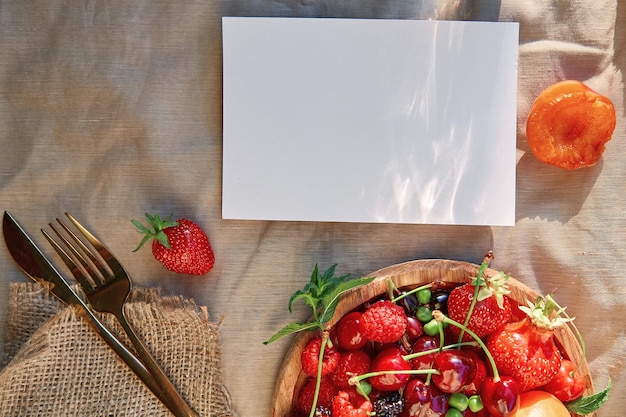 Summer rustic stationery card mockup with hard shadows sunlight and fresh seasonal fruits berries Top view flat lay