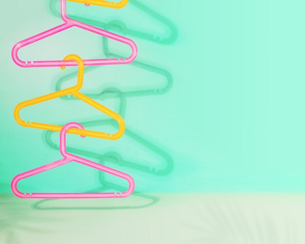 Photo summer sale composition with colored plastic hangers on a mint background with shadows