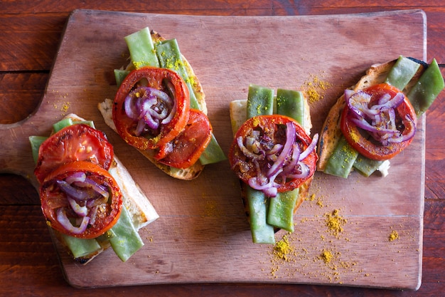 Photo summer sandwich prepared with fried red onion, tomato and kidney beans