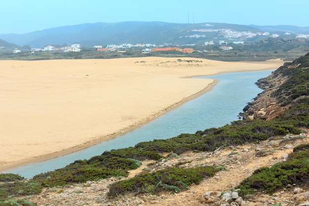 Летний песчаный пляж Прайя-да-Бордейра. Туманный вид (Каррапатейра, Алгарве, Португалия).