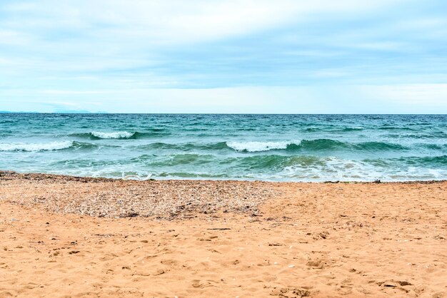 Summer scene with blue sea water white foam and yellow sand with selective focus Vacation or holiday concept Nature background with copy space