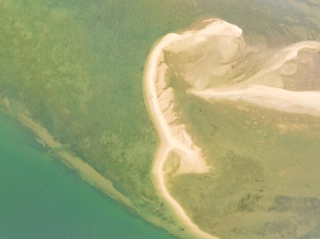 Summer sea nature backgroundAerial view of texture sand water backgroundSea surface ocean waves backgroundTop view beach background