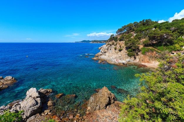 Summer sea rocky coast view with trees and beach (Catalonia, Costa Brava, Spain).