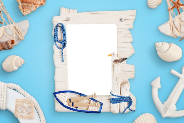 Photo summer sea travel photo frame on blue desk surrounded with shells boat anchor lifebelt