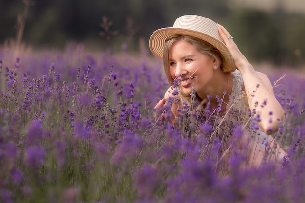 La stagione estiva. campi di lavanda. una ragazza con un cappello di paglia in un campo di lavanda. zona rurale