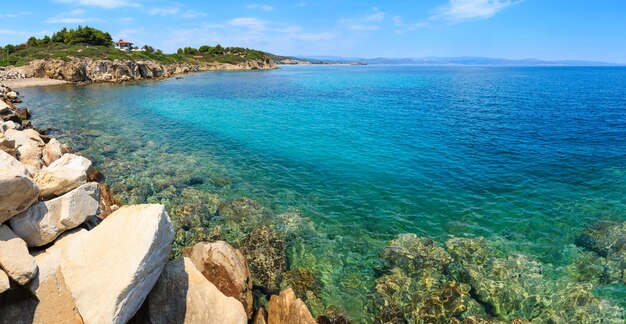 夏のシトニアの海岸線とビーチと家のあるエーゲ海の風景（Lagonisi、ハルキディキ、ギリシャ）。パノラマ。