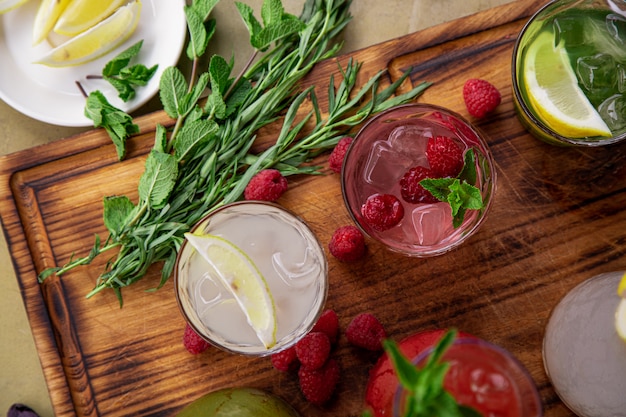 Summer soft drinks, a set of lemonades. Lemonades in jugs on the table, the ingredients of which they are made are arranged around.