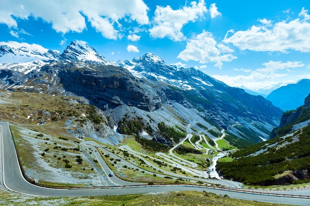 高山道路と斜面に雪が降る夏のステルヴィオ峠（イタリア）