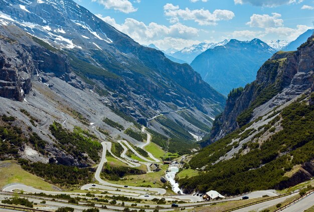 高山道路と斜面に雪が降る夏のステルヴィオ峠（イタリア）