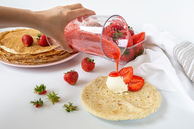 Summer strawberry season. Strawberries with pancakes and ice cream and Water with ice and strawberry syrup.