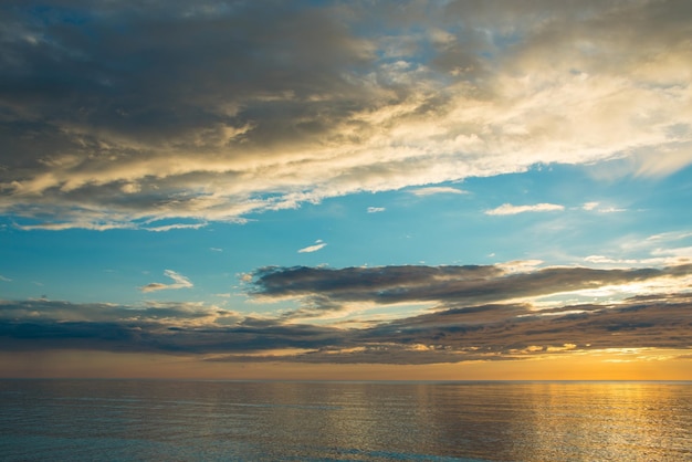 Summer sunset on the beach with clouds over the sky