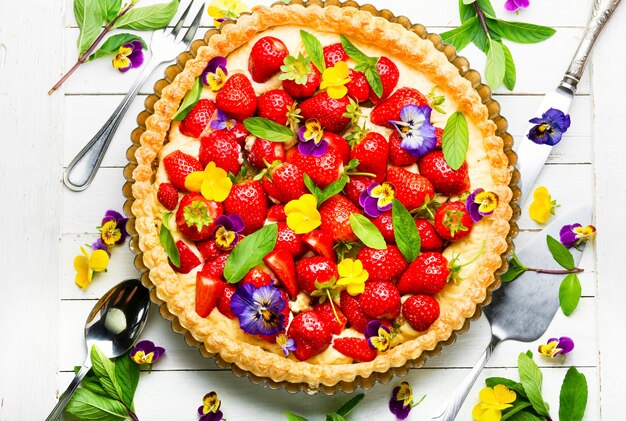 Summer tart with strawberries.Pie decorated with mint and flowers