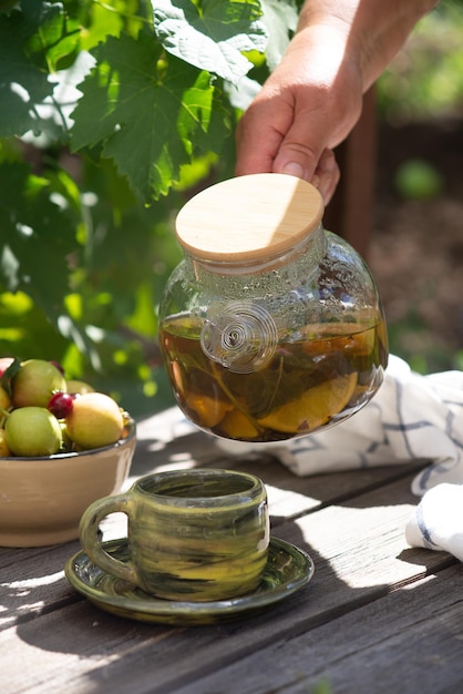 急須の夏のお茶は夏の背景にお茶を注いでいます