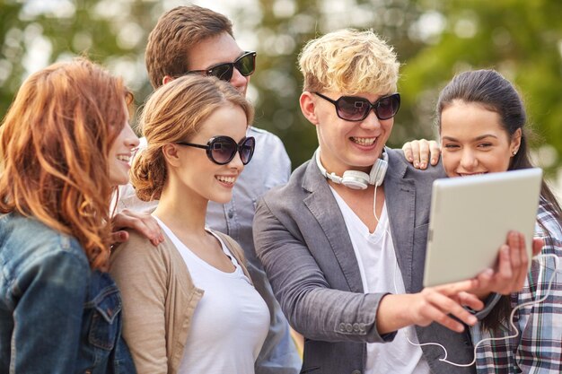 summer, technology, education and teenage concept - group of happy students or teenagers with tablet pc computer taking selfie