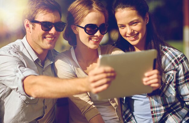 summer, technology, education and teenage concept - group of happy students or teenagers with tablet pc computer taking selfie