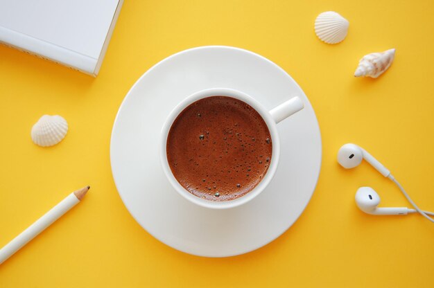 Summer themed desk with turkish coffee book pencil\
headphone