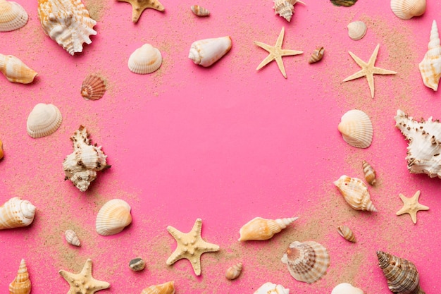 Summer time concept Flat lay composition with beautiful starfish and sea shells on colored table top view