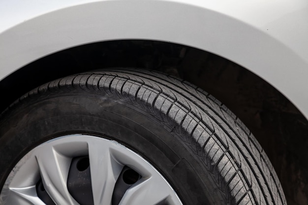 Summer tire with black tread on a silver car for replacement and sale in the garage Spare parts for vehicles