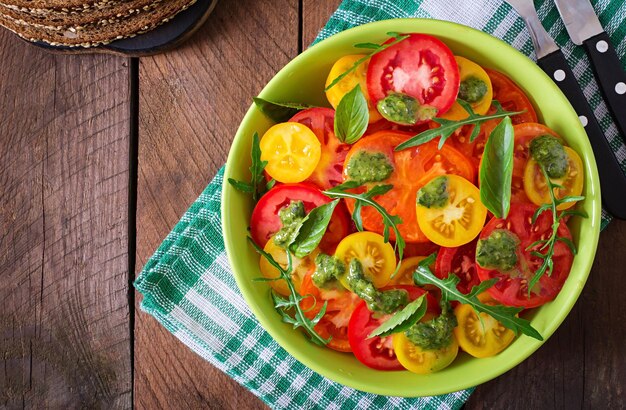 Summer tomato salad with basil pesto and arugula