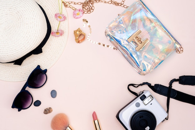 Summer travel accessories. camera, hat, glasses and top view on a light background.