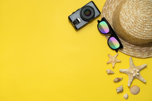 Concetto di viaggio estivo sfondo per le vacanze estive occhiali da sole con cappello di paglia e stelle marine con fotocamera