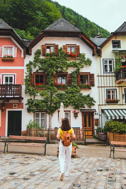 Summer travel concept woman looking at beautiful building at hallstatt central city square