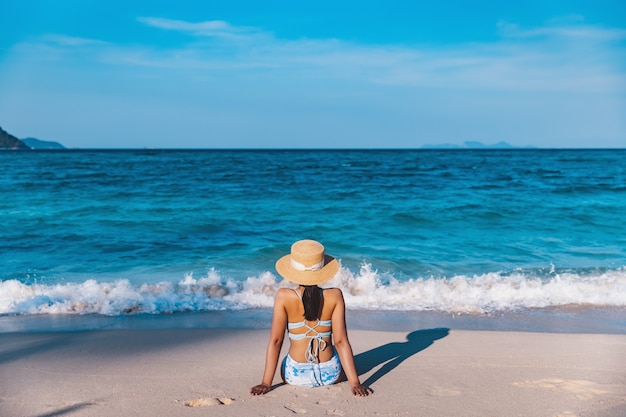 Concetto di vacanza di viaggio estivo, donna asiatica viaggiatore con bikini e cappello rilassarsi sulla spiaggia del mare al giorno a koh lipe, satun, thailandia