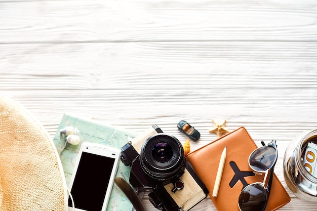 Photo summer travel wanderlust concept space for text flat lay map camera sunglasses passport money phone hat shells car toy on white wooden background top view hello holiday planning vacationxa