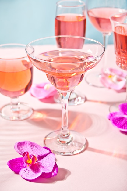 Summer tropical pink cocktail in a different glasses decorated pink orchid flowers.