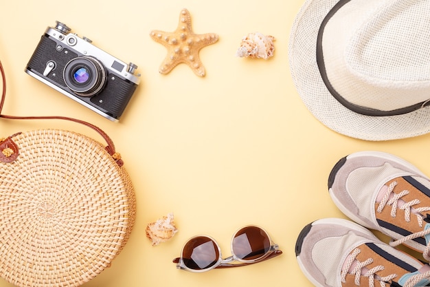 Summer vacation background. Sneakers, rattan bag, sunglasses, hat and retro camera