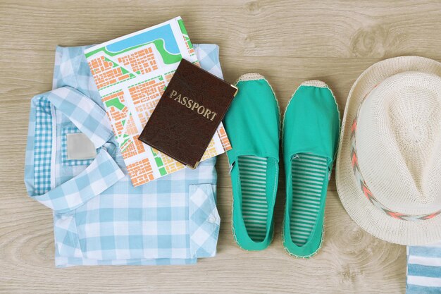 Summer vacation clothes shoes and hat on wooden background