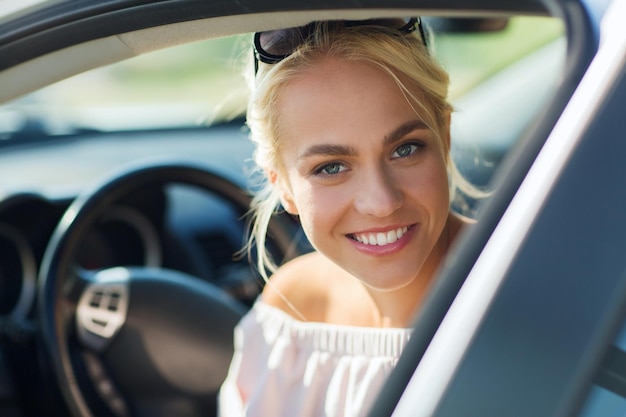 summer vacation, holidays, travel, road trip and people concept - happy smiling teenage girl or young woman in car