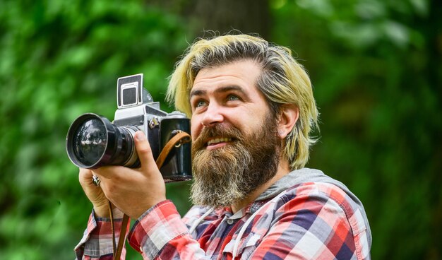 Summer Vacation photographer hold retro camera journalist is my career reporter make photo vintage camera capture these memories SLR camera hipster man with beard use professional camera