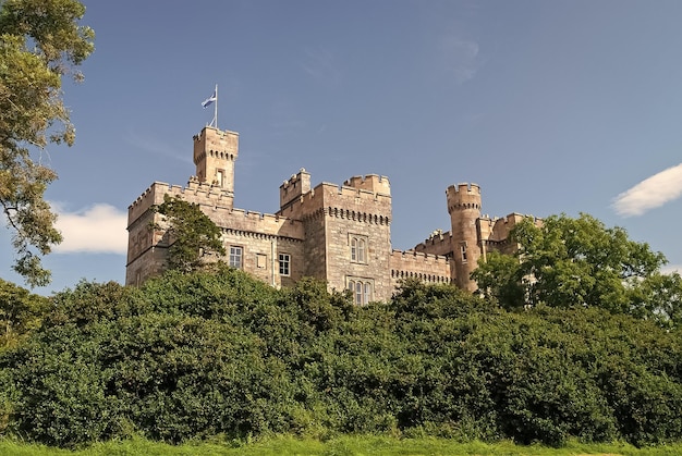 Vacanze estive e voglia di viaggiare castello con alberi verdi a stornoway regno unito castello di lews in giardino sul cielo blu architettura e design in stile vittoriano punto di riferimento e attrazione