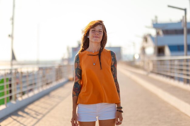 Summer vacation Young happy Caucasian woman with tattoo smiling Copy space Concept of freedom and happiness