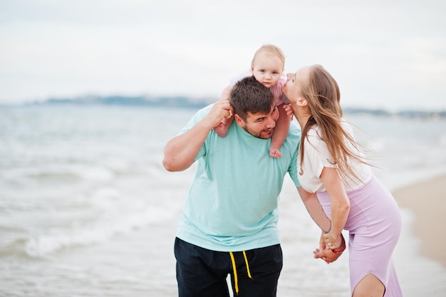 夏休み両親と子供たちとの野外活動幸せな家族の休日海砂浜での父妊娠中の母の赤ん坊の娘