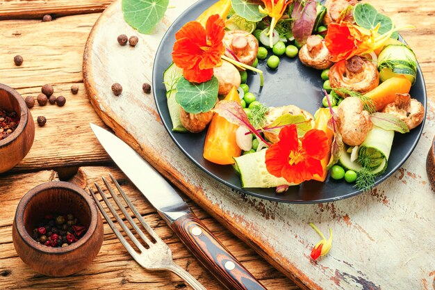 Photo summer vegetable salad decorated with nasturtium flowers