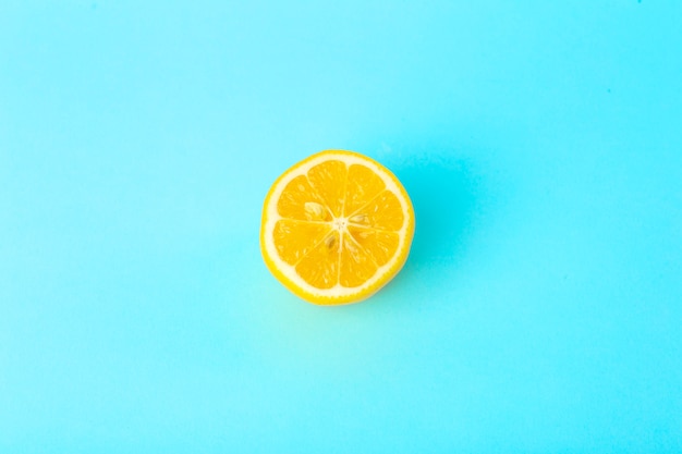 Summer and vitamins background. Lemon on a blue background, minimal food concept