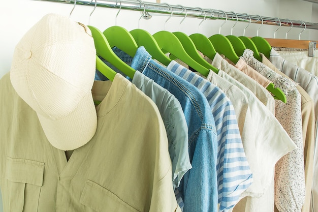 Summer wardrobe with linnen clothes on green hangers