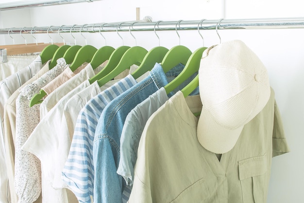 Summer wardrobe with linnen clothes on green hangers