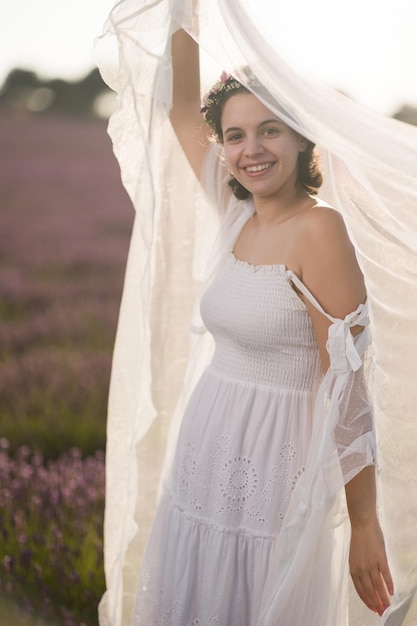 プロヴァンスラベンダー畑の牧草地ヒスパニック系の若い女性の風景の夏のウェディング花嫁のドレス