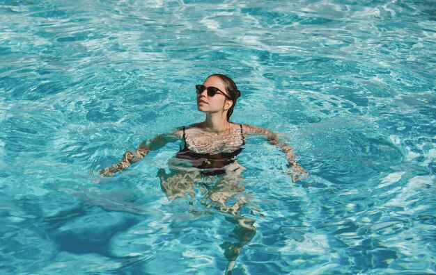 Photo summer weekend and vacation pool resort happy woman in swimmingpool summertime vacation pool party