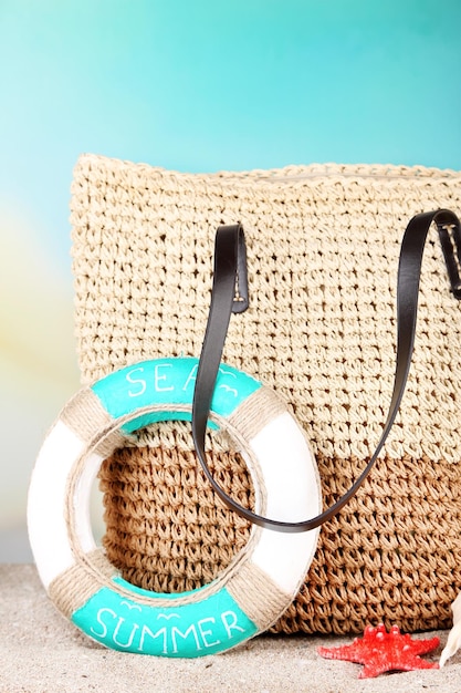 Summer wicker bag on sand on nature background